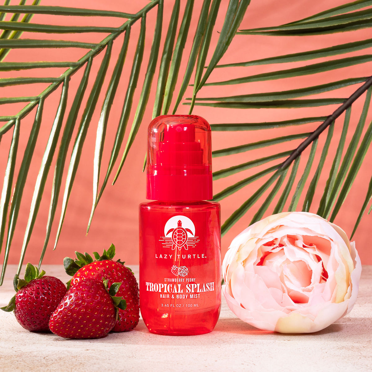 Strawberry Peony mist bottle beside strawberries and a pink peony beneath palm leaves.