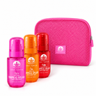 Lazy Turtle Smell Like The Tropics bundle with Coco Colada, Pomelo Sun, and Strawberry Peony hair and body mists beside a pink cosmetic bag.